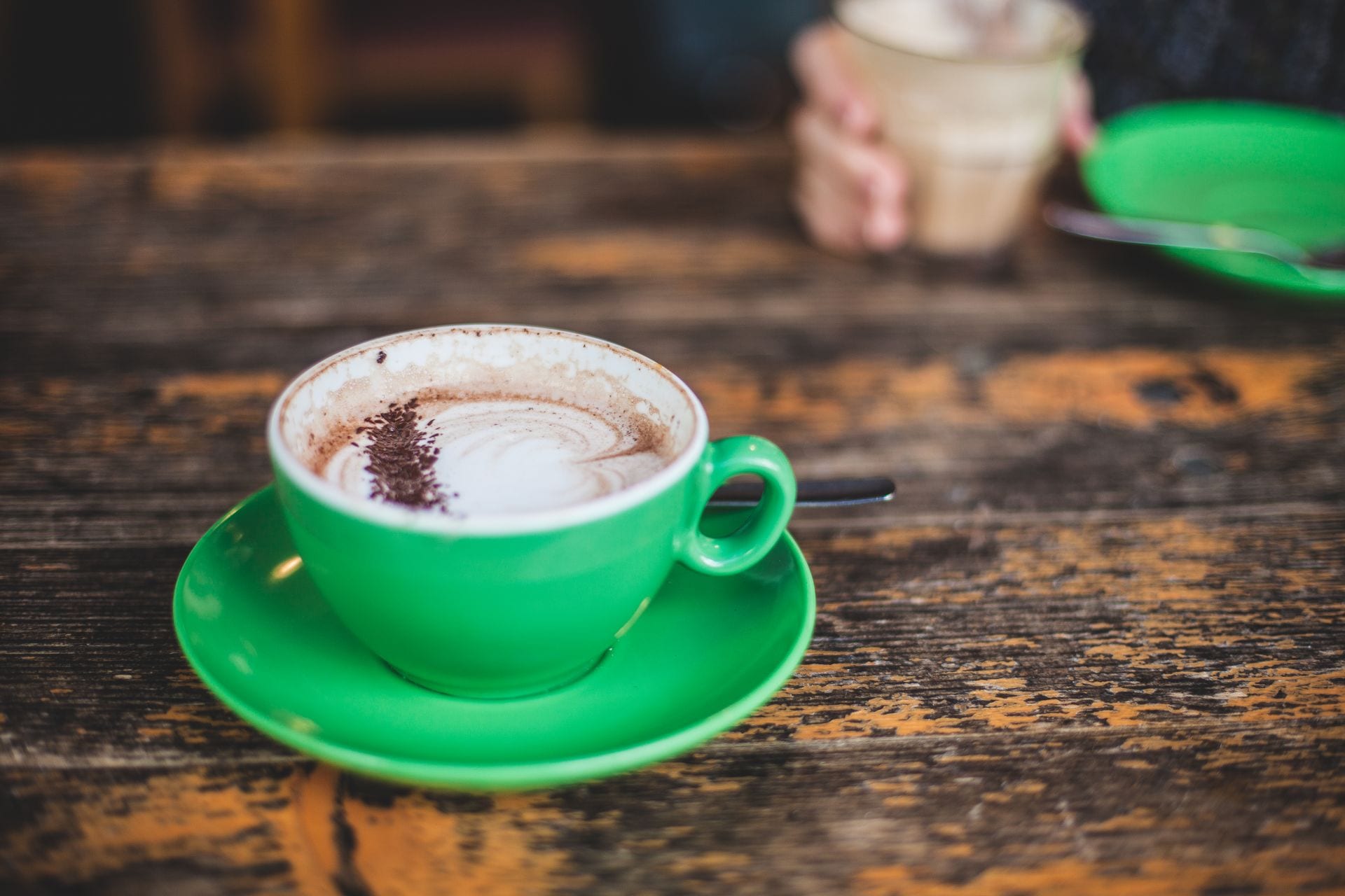 Café con leche servido en taza sobre mesa de madera